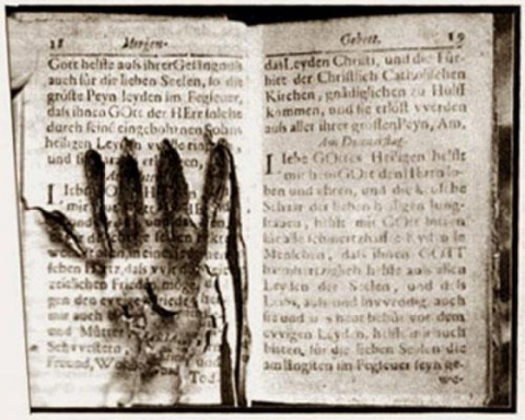 Libro di preghiere su cui è impressa un&#039;impronta di mano. Museo delle Anime del Purgatorio, Roma.